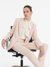 A lady wears a blazer with cropped pants.